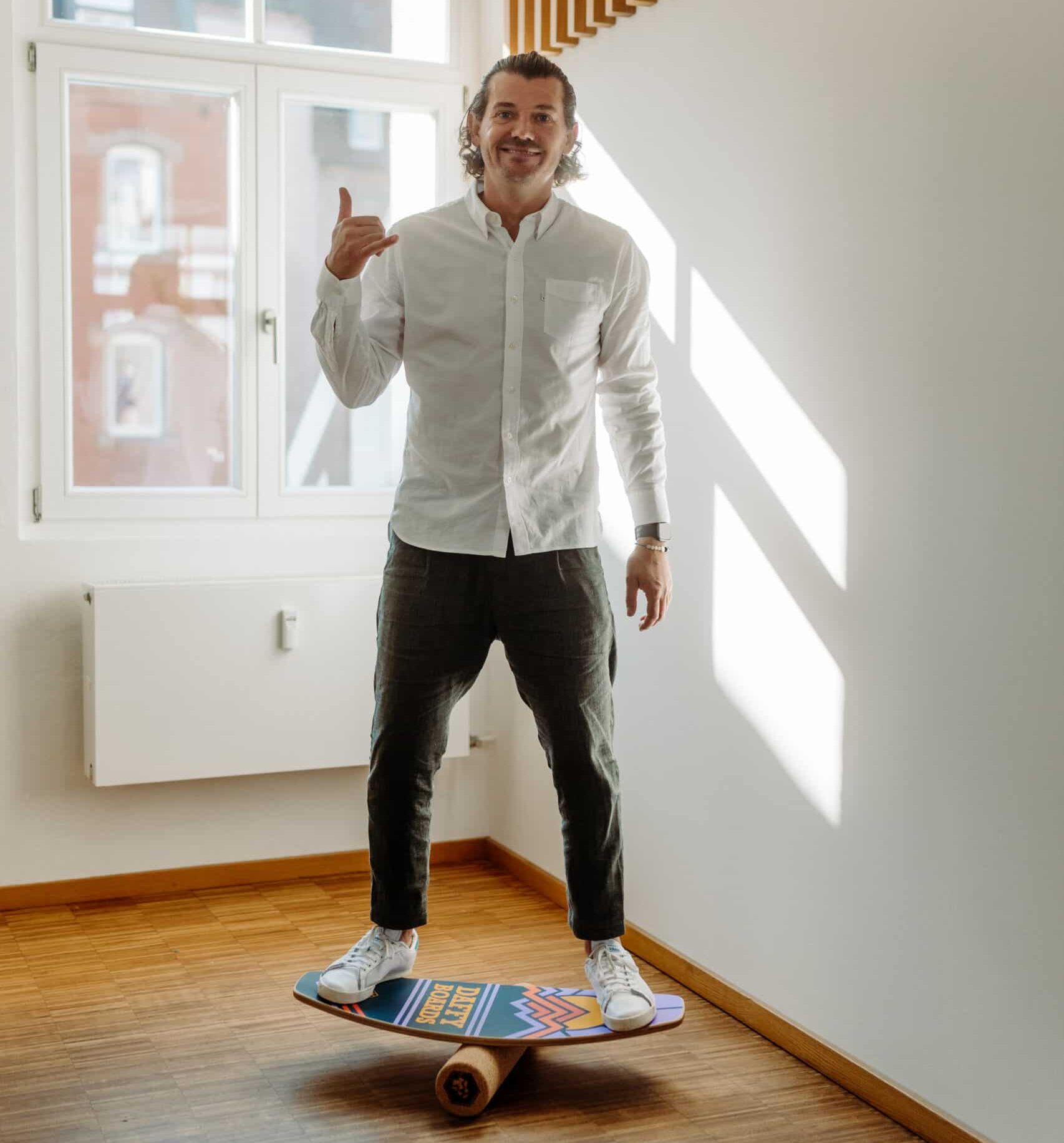 Toni balanciert auf einem Balance-Board, während er spielerisch auf den Wellen des Boards steht.